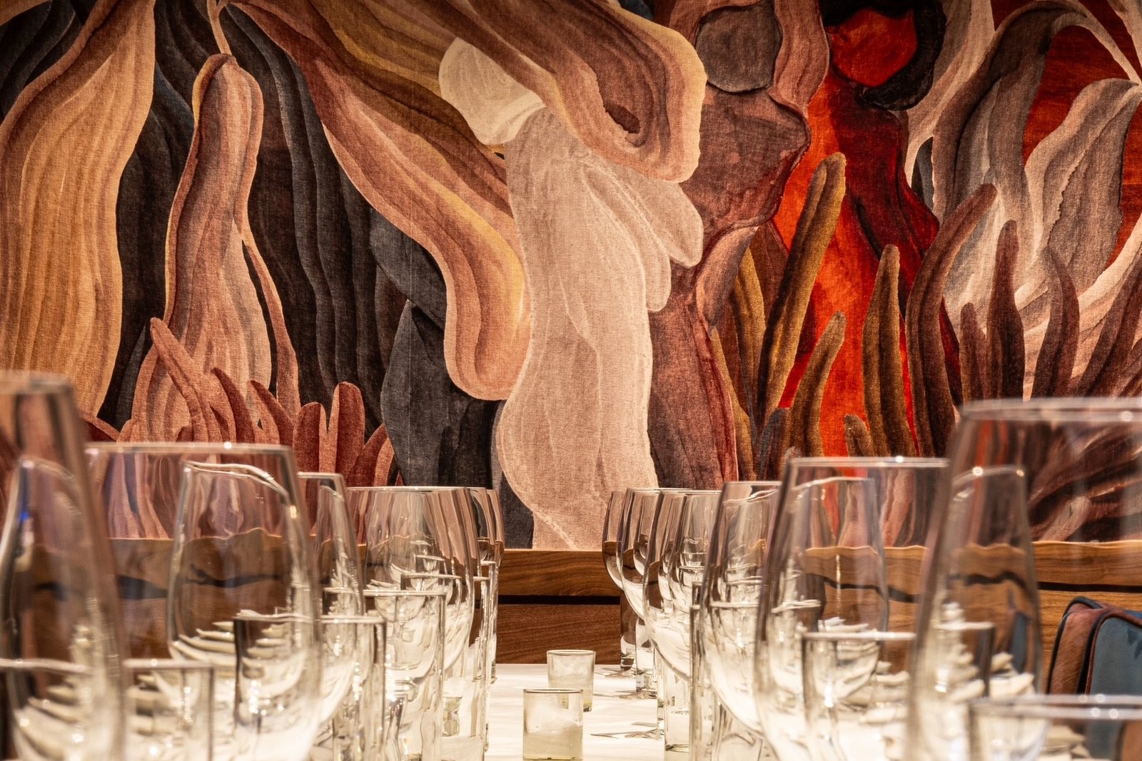 Glasses lined up in a row with artwork in the background